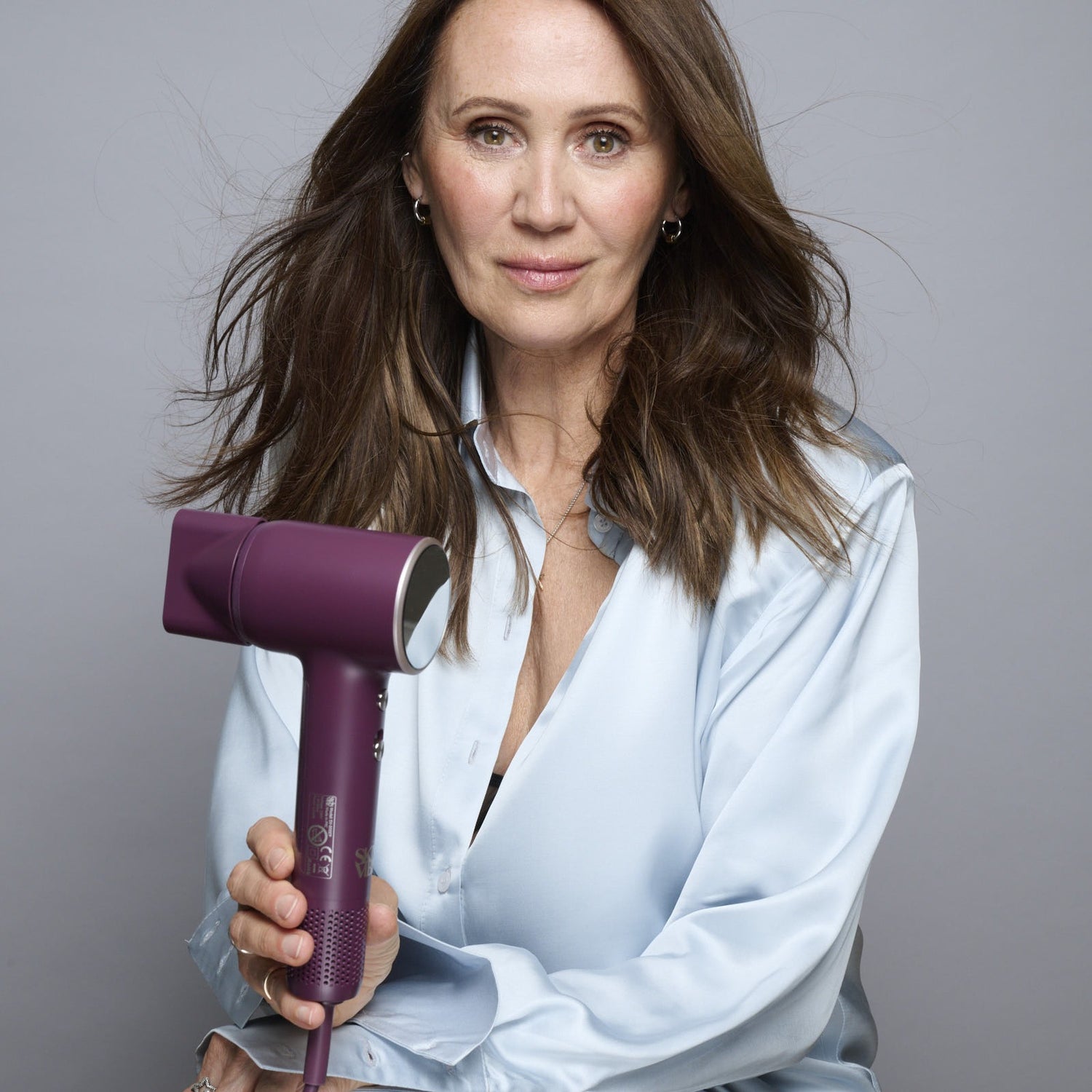 Anna Nowak-Ibisz, współzałożycielka SkinVibe, z mini suszarką Nova PlasmaGo w kolorze bakłażanowym